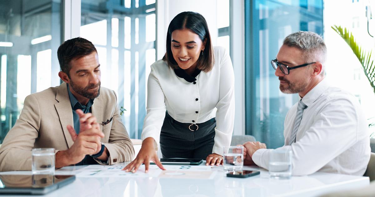 3 professionals reviewing documents at a table