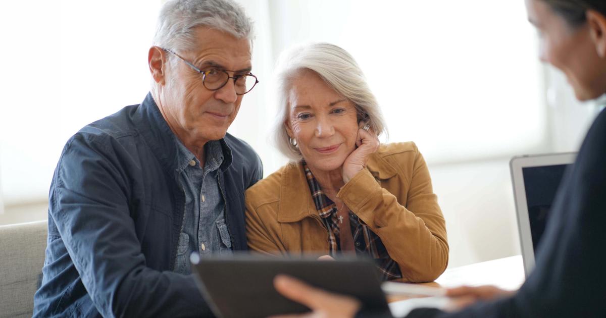 Older Christian couple reviewing their biblical investment portfolio with a financial advisor