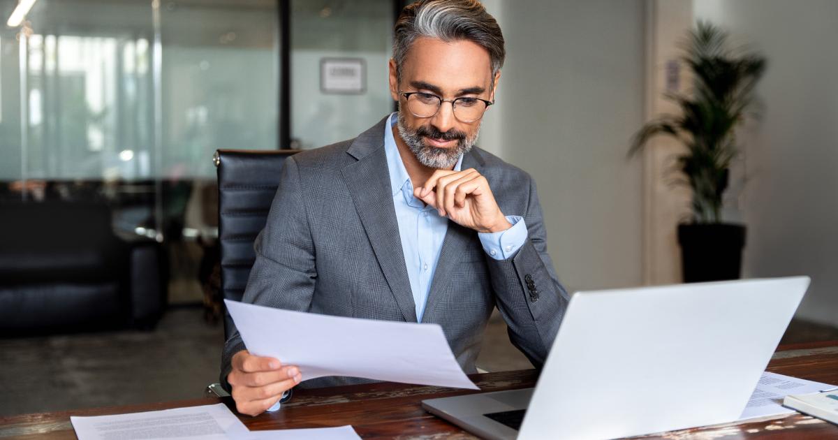 Thoughtful researcher analyzing documents and notes at his desk during biblical study