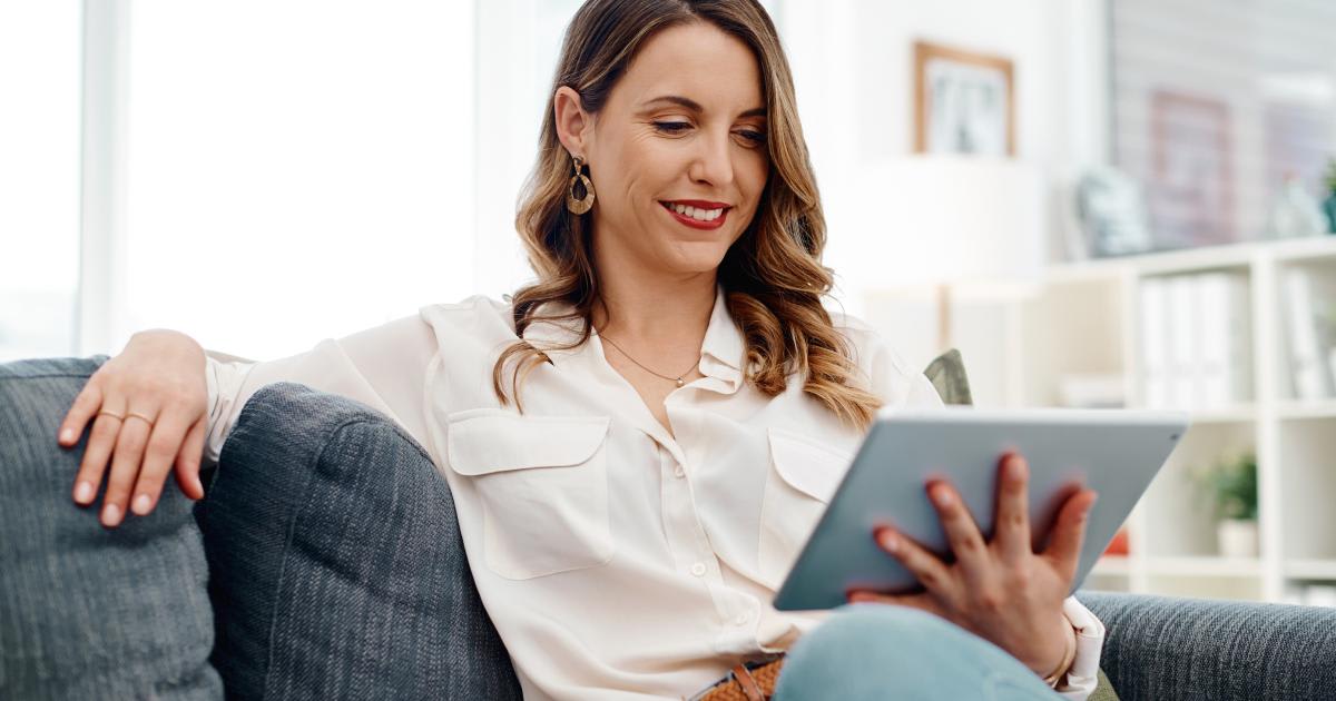 Investor reviewing quarterly portfolio performance and investment updates on a digital tablet at home