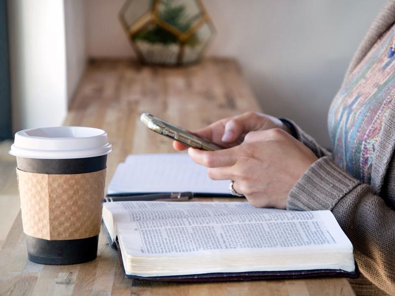 Financial advisor researching values-aligned investing in Canada with open Bible and smartphone