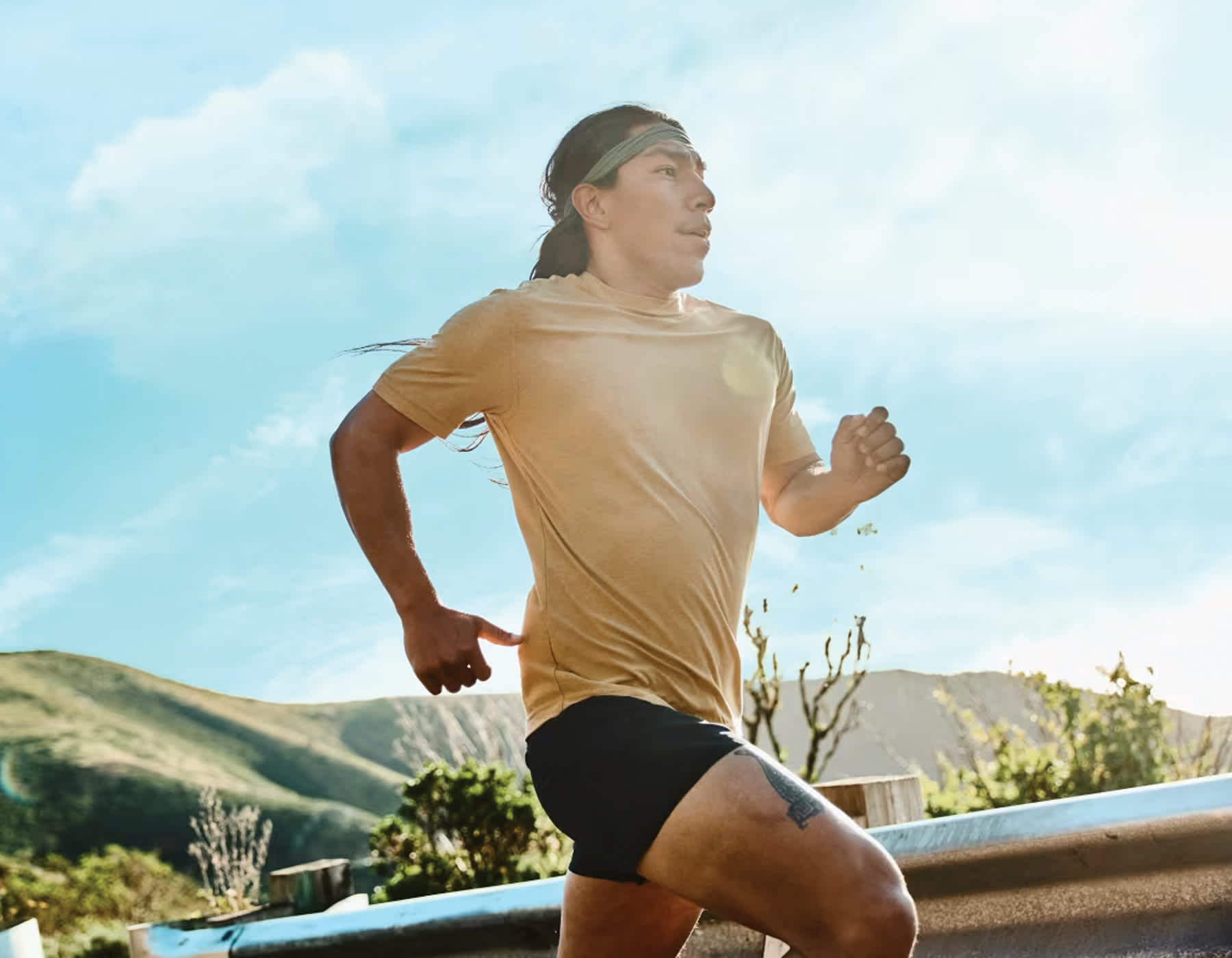 Male running along a road with hills in the background