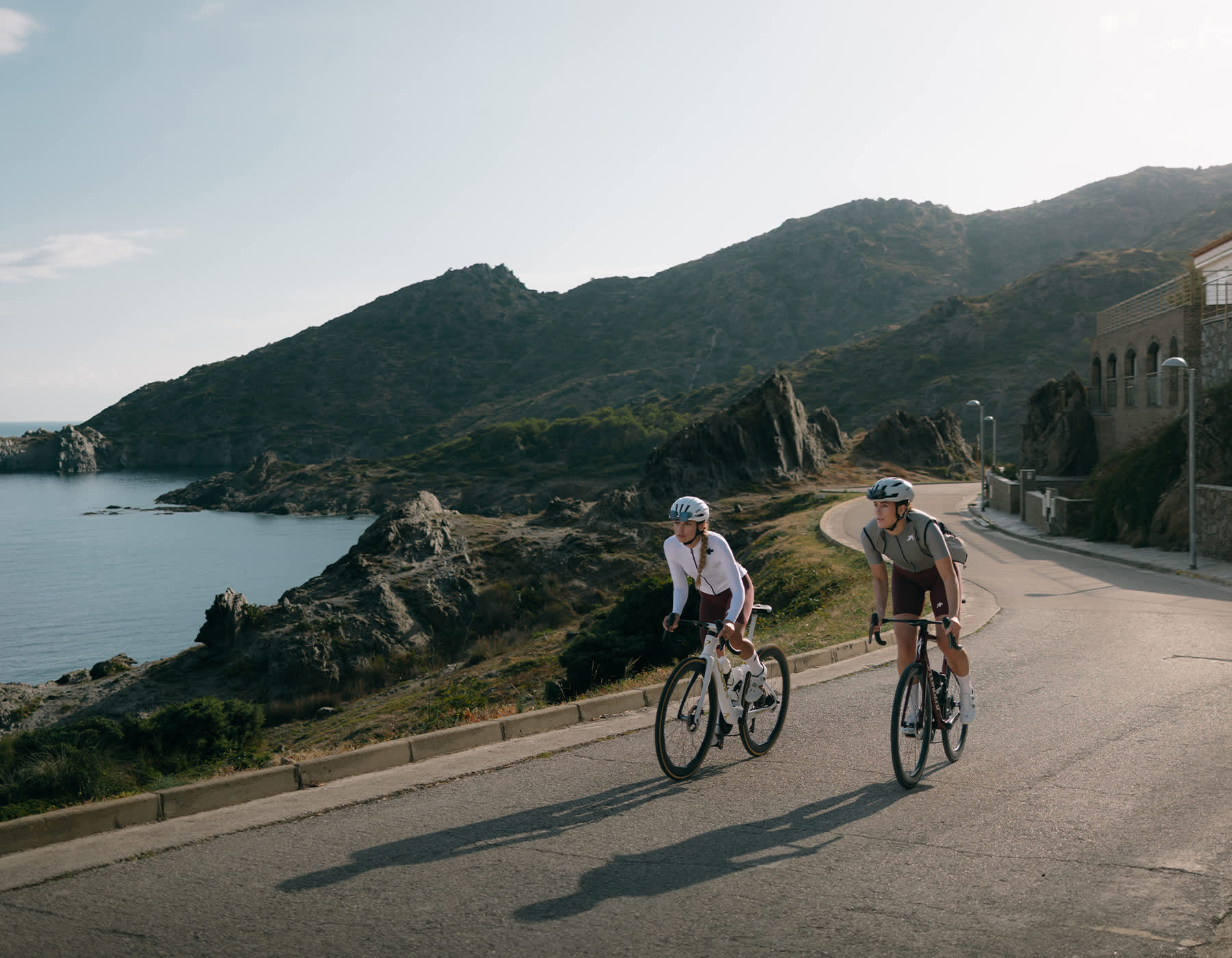 Two women cycling on road bikes wearing ASSOS premium women’s cycling apparel during a countryside road ride