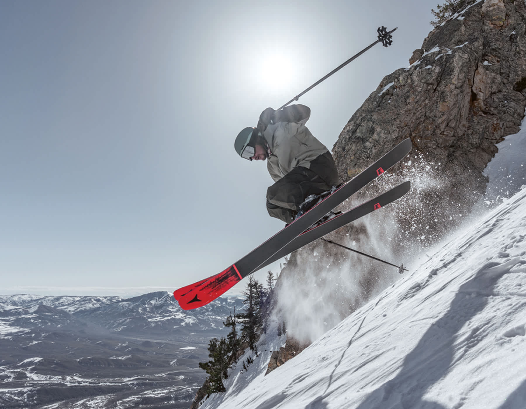 Green Skis. Atomic skier going off a jump wearing Atomic Alpine skis and Atomic Winter Outerwear.