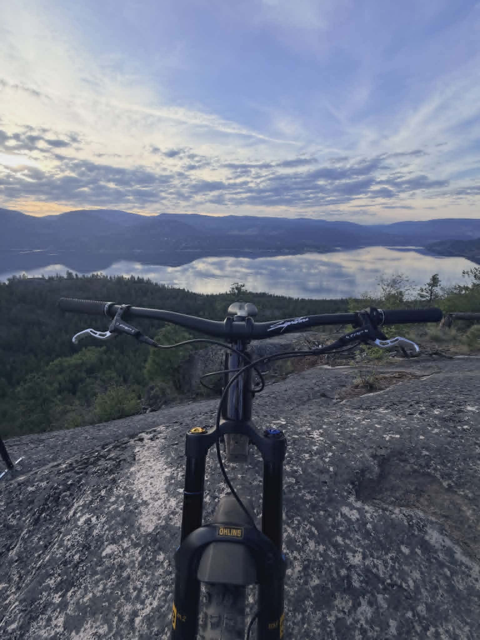mountain bike on slab rock at predator ridge with a view of the okanagan lake