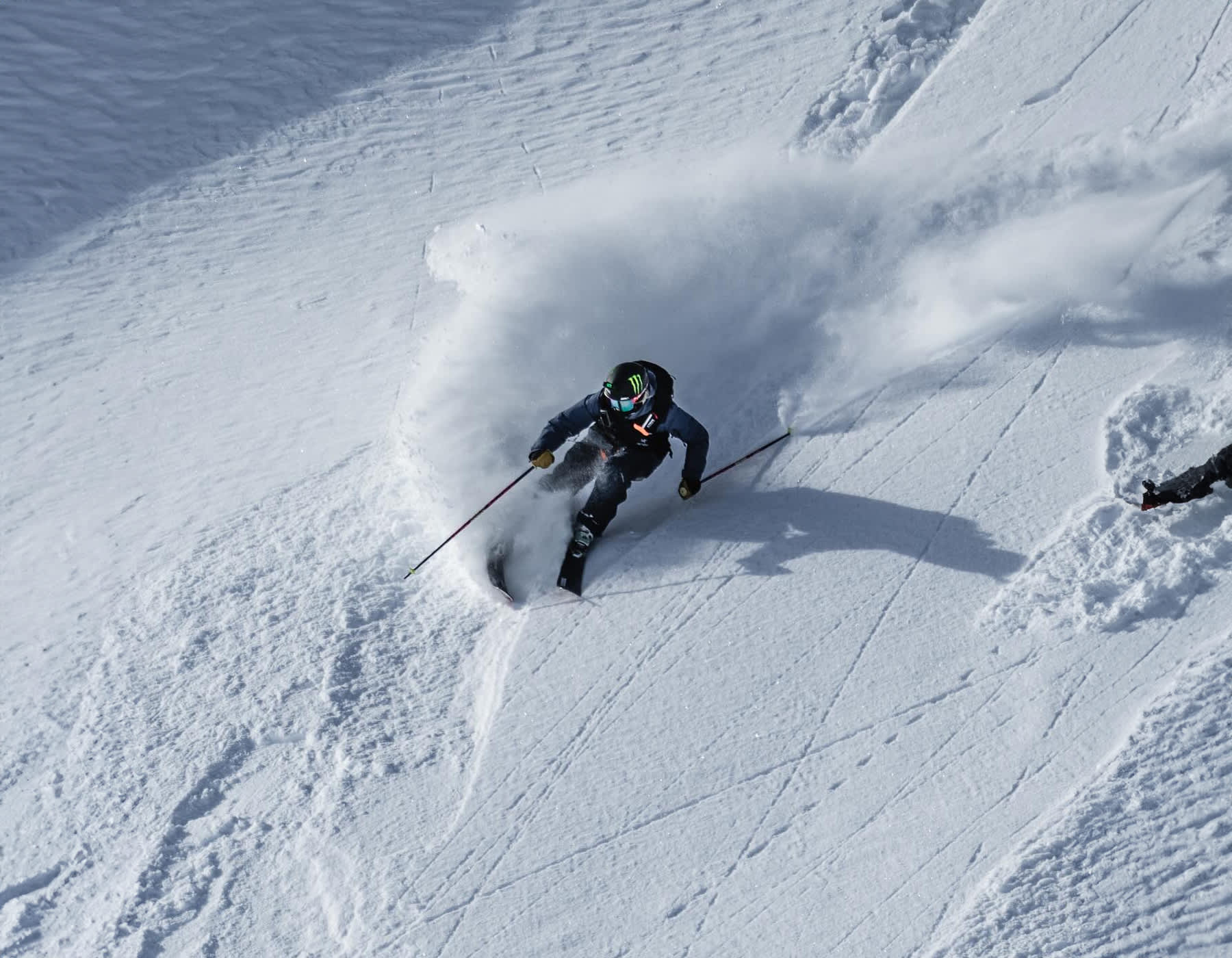 Skier descending a powder-covered mountain wearing a BlackStrap balaclava, enjoying winter conditions. BlackStrap – shop at Fresh Air Kelowna