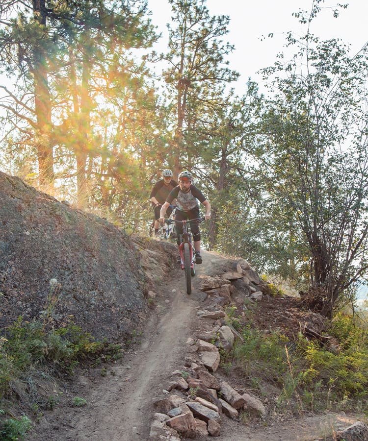 Two riders from Fresh Air bike shop descending Okanagan trail in Kelowna