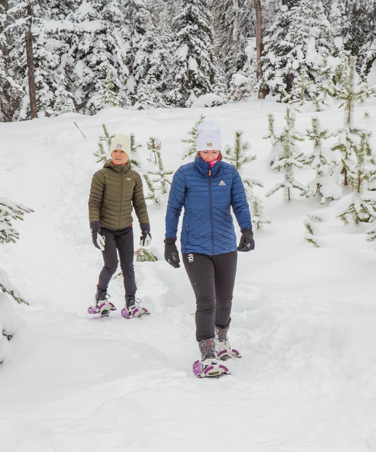 Family of two from Fresh Air wearing winter layers on snowshoe trail at Telemark Kelowna