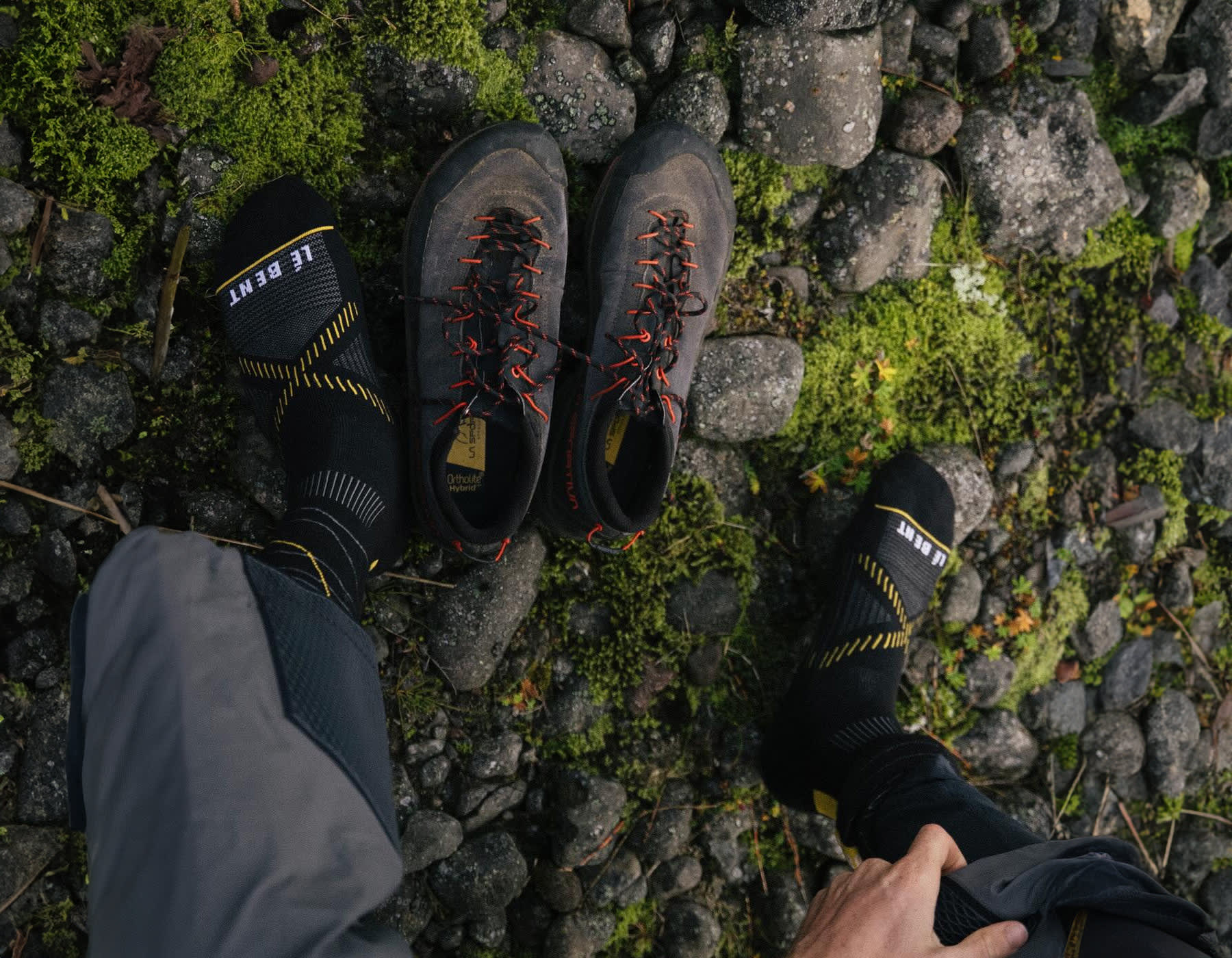 Men’s feet in the grass wearing LÉ BENT active lifestyle socks with hiking shoes off