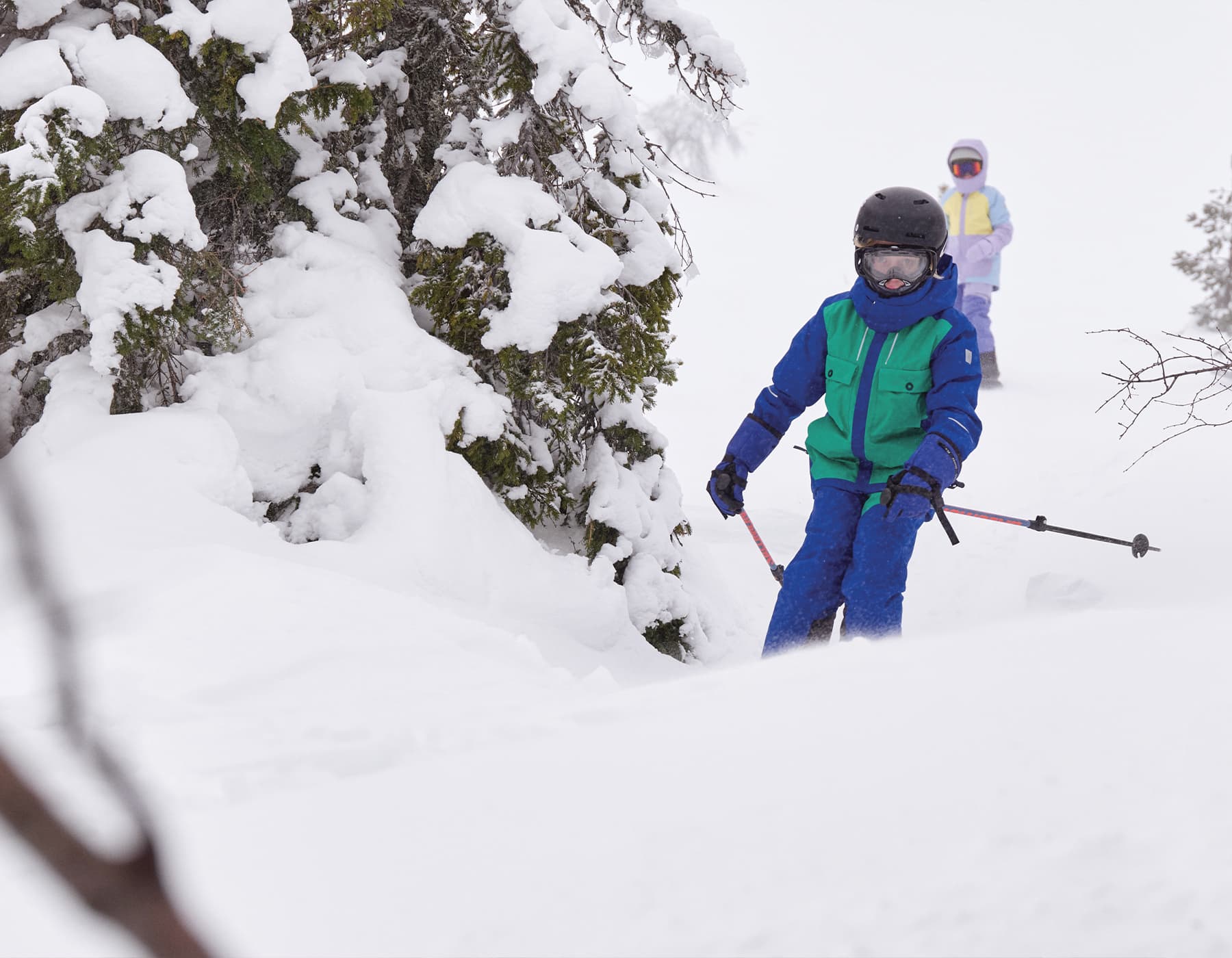 Kelowna hiking gear. Two runners with hydration packs and running jackets going up a grassy mountain during sunset