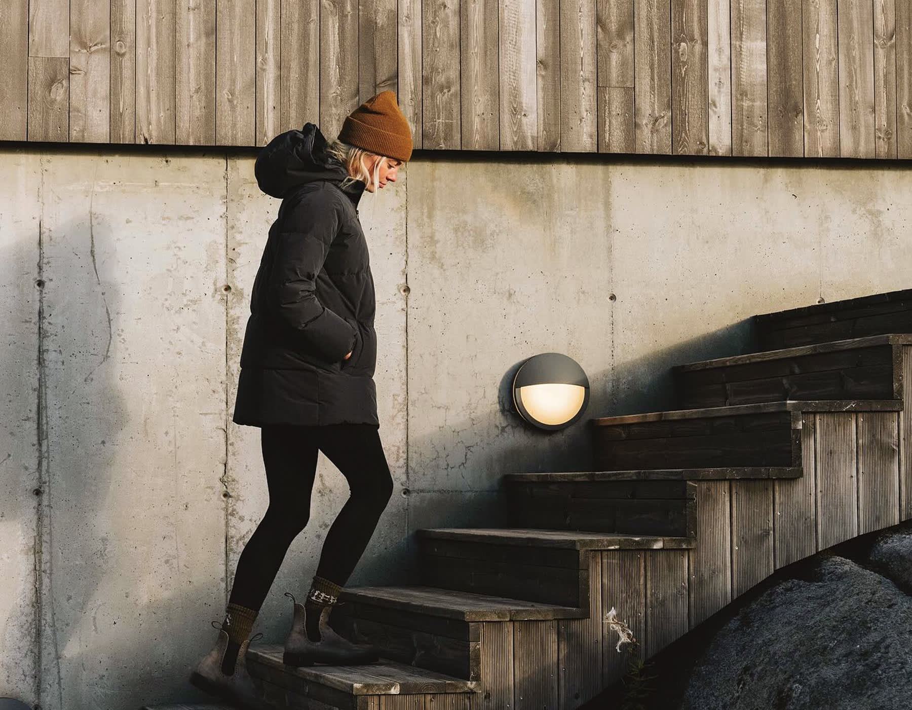 A girl walking up a set of stairs outside wearing a warm winter Vuori jacket.