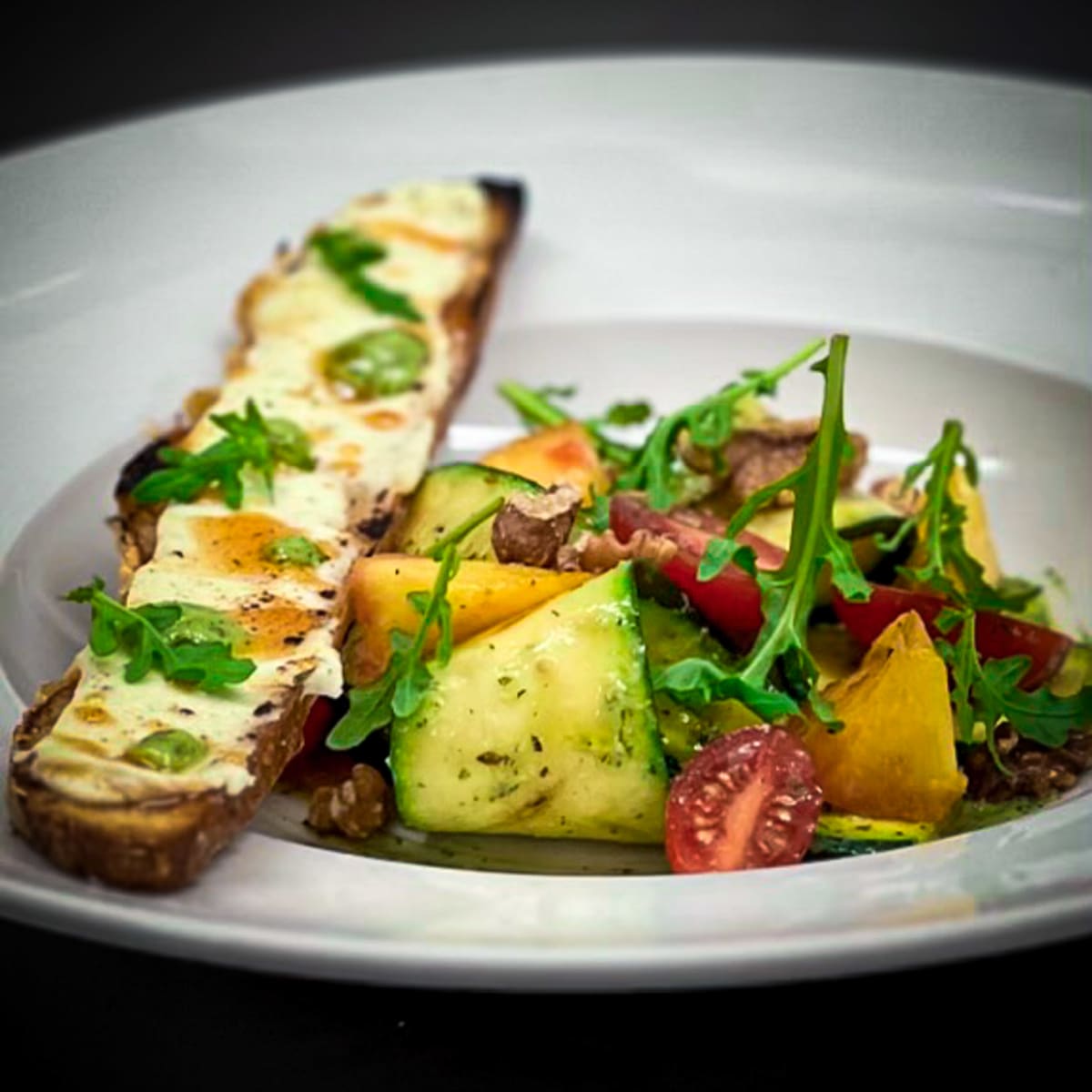arugula-and-grilled-zuchini-salad-tossed-in-a-dill-vinaigrette,-warm-goat-cheese-croutons-and-spicy-honey-drizzle