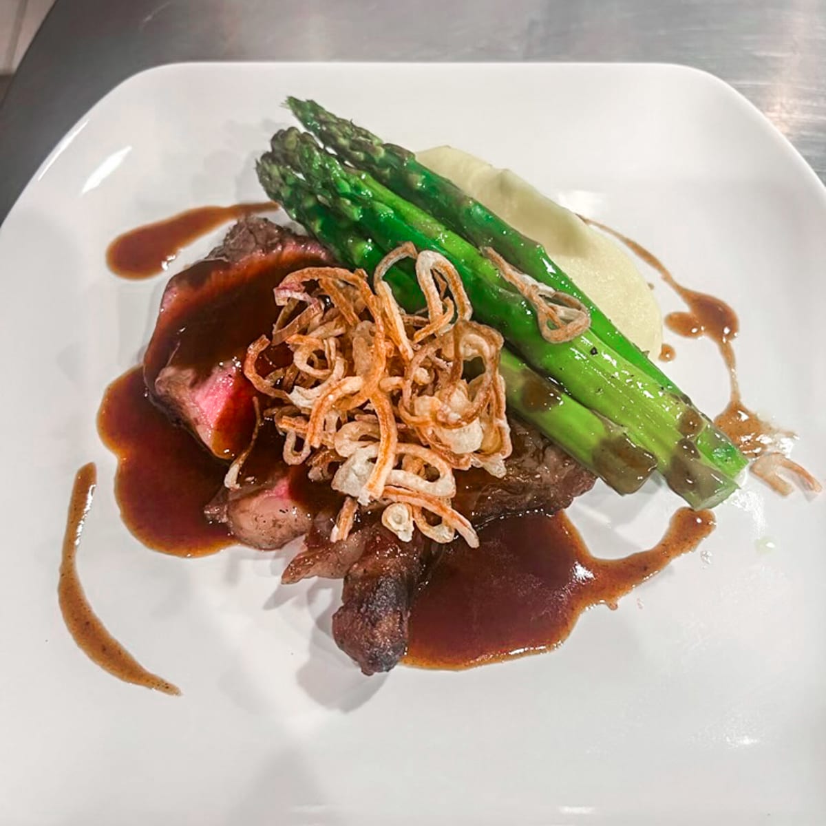 sous-vide-beef-striploin,-served-with-pomme-puree,-grilled-asparagus,-fried-shallots-and-bordelaise-sauce