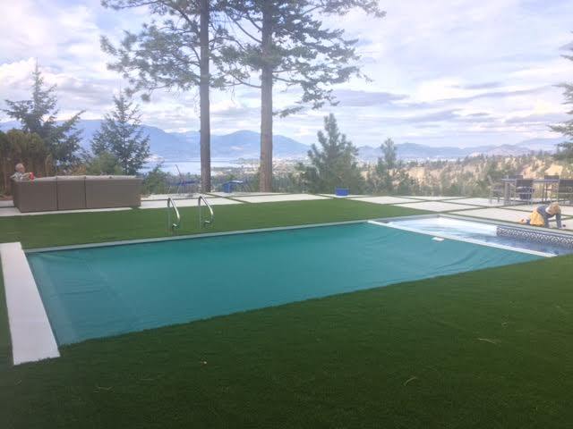 Kelowna pool cover surrounded by synthetic lawn